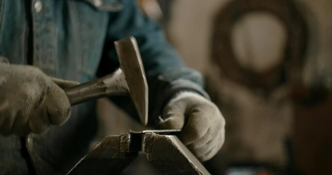 Locksmith hammers sheet metal, shaping metal manually, metalwork at workshop, 4k 60p Prores HQ
