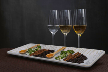 Catado de tequilas blanco, reposado y añejo; plato de cerámica con canela, cucharas con miel de agave, granos de café y cáscara de limón.