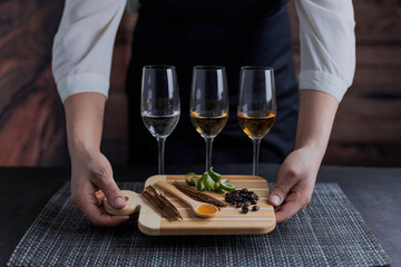 Catado de tequilas blanco, reposado y añejo. Mujer mexicana sosteniendo una tabla para cortar...