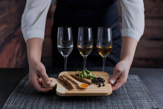 Catado de tequilas blanco, reposado y a&ntilde;ejo. Mujer mexicana sosteniendo una tabla para cortar mostrando canela, c&aacute;scara de lim&oacute;n, granos de caf&eacute; y miel de agave.