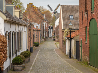 Picturesque street leading to the old windmill in the town of Buren, Betuwe region