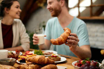 Close-up of couple eating breakfast at talking in the morning at home.