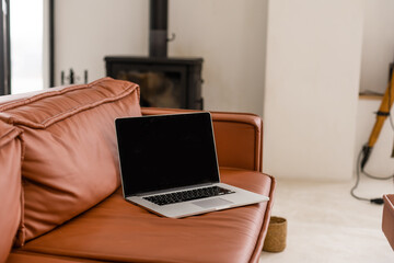 Laptop with blank screen on sofa in livingroom