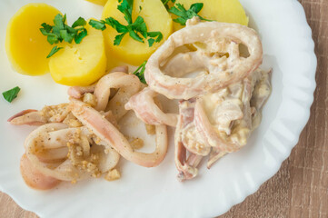 boiled potatoes with squid rings in a creamy sauce with spices. Delicious home-cooked squid dinner