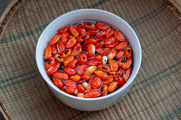 Wild seeds of the Natal mahogany African tree (Trichilia emetica) known as mafura soaked in water for being eaten after soft
