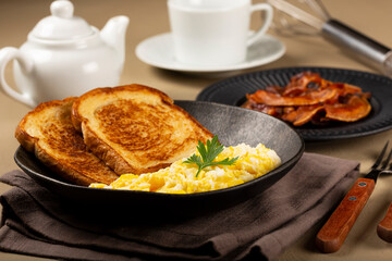 Breakfast. Scrambled egg with toast and bacon.