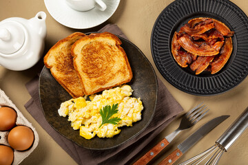 Breakfast. Scrambled egg with toast and bacon.