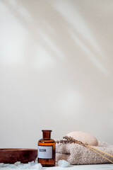 Home spa, cosmetic oil in a bottle, wooden bowl on a white table - 426467700