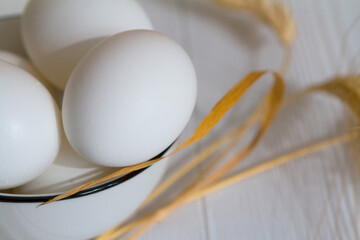 White eggs in a bowl on a wooden table - 426467742