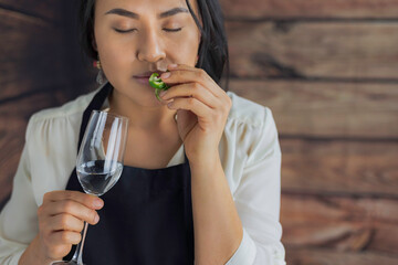 Catado de tequilas. Mujer mexicana sosteniendo una copa de tequila blanco y oliendo una cáscara de...