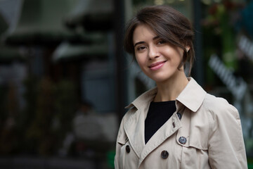 Smiling brunette woman wears trench