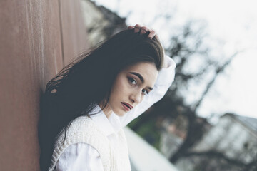 Outdoor portrait of a young beautiful fashionable lady wearing stylish coat . Model looking aside. Female fashion concept. City lifestyle. Close up.