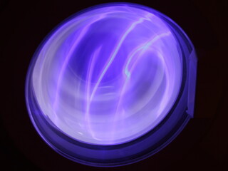Washing machine round blue glass door purple lighting in dark, abstract round blue circle shape