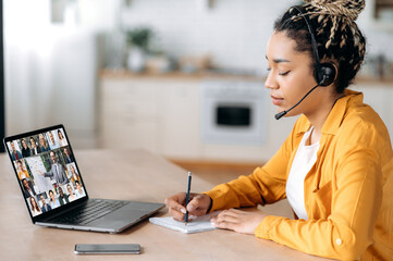 Online webinar, business meeting. Side view of african american woman, communicates with business...