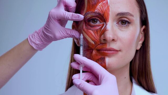 Cosmetic injection in the face. Young woman with half of face with muscles structure under skin. Model for medical training on a light background. Close up video of face human anantomy.