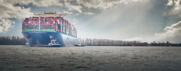 Large container ship in port in Hamburg in slightly cloudy weather