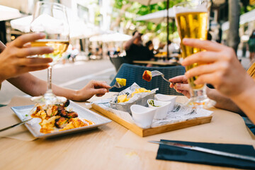a glass of beer and wine on a table with utensils two girls have dinner together in a restaurant on...