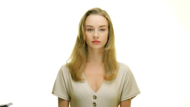 Portrait of a serious woman looking at the camera. Woman standing in studio with no face blank expression.
