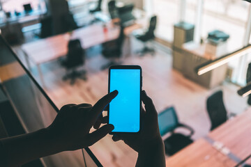 Blank phone screen mockup with office blurred background