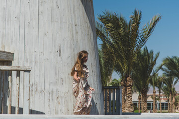 girl in cafe on the beach. young slim beautiful woman on sunset beach, playful, dancing, running, bohemian outfit, indie style, summer vacation, sunny, having fun, positive mood, romantic