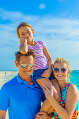 Family at the beach, mother, father and daughter, close-up, dressed in colorful tropical outfits