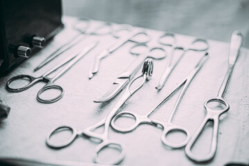 Fototapeta premium Old Medical And Surgical Instruments. Many Old Surgical Instruments For Surgery. Black And White Toned Shot. Old Different Metal Medical Instruments Objects. Retro Stainless Surgical Equipment Tools