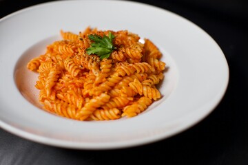 Pasta with butter and tomato sauce in a white porcelain plate