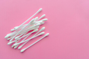Cotton buds on pink background.  Copy space is on the right side.  Flat lay top view photo.