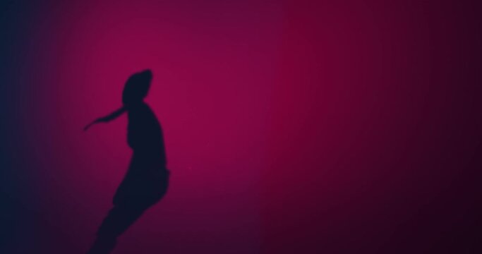 Shadow of young girl dancing creative passionate fiery dance in pink studio light. Expression and rhythm. Copyspace