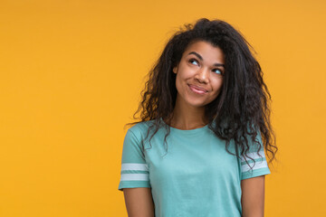 Portrait of beautiful flirty coquette brunette african american woman with curly hair looking aside...