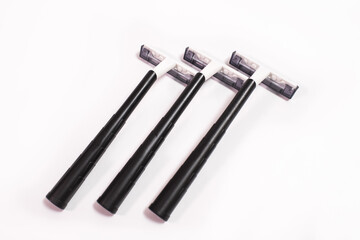 Three black disposable razors isolated on white background