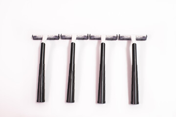 Four black disposable razors isolated on white background