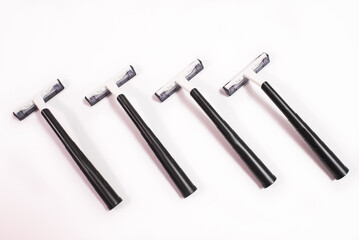 Four black disposable razors isolated on white background