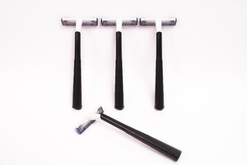 Four black disposable razors isolated on white background