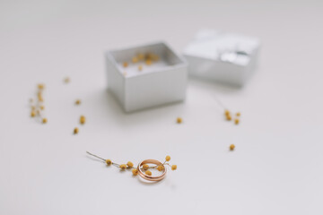 Box with golden engagement ring on flowers background, top view. Wedding, Marriage proposal concept