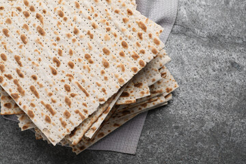 Stack of traditional matzos on grey table, above view