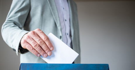 male hand putting vote in ballot