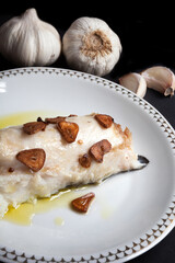 Hake head fillet baked with garlic. Homemade food concept