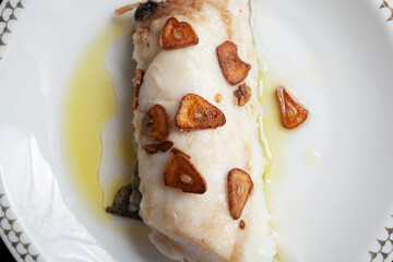 Hake head fillet baked with garlic. Homemade food concept