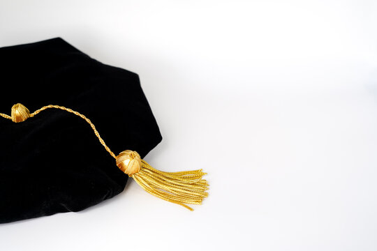 Isolated traditional black phd doctoral tam cap with gold tassel