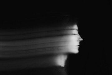 Blurred female portrait in the dark.