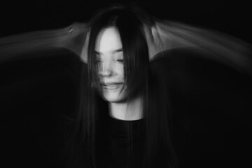 Blurred female portrait in the dark.