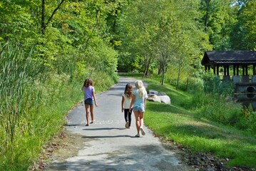 Three little girls taking a hike through the woods