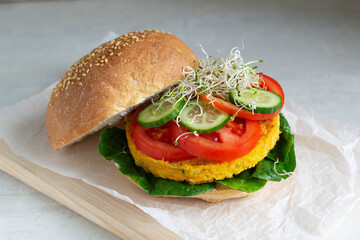 Veggie burger with chickpea cutlet with tomato, cucumber, spinach and microgreen. Vegetarian food concept. Horizontal orientation.