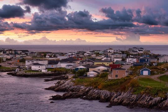 Homes in a little town on the rocky Atlantic Ocean Coast. Colorful Sunset Sky Art Render. Taken in Channel-Port aux Basques, Newfoundland, Canada.