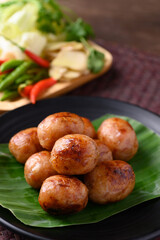 Thai sausage or Isan sausage (grilled fermented rice with minced pork) eating with fresh cabbage, ginger, and chili peppers