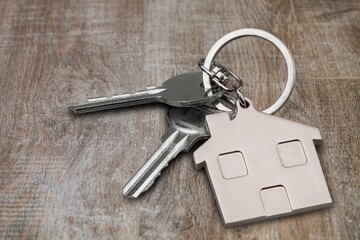 Metal silver house keys with house figure on desk