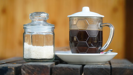 Black coffee and sugar in a glass cup. Focus selected, backround blur