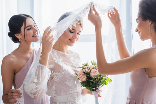 african american woman raising veil of bride holding wedding bouquet. - Powered by Adobe
