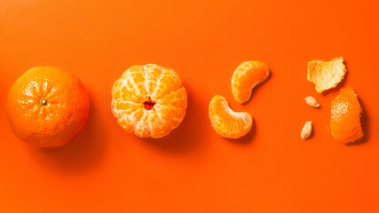 Tangerines on an orange background: whole, peeled, wedges and peels. Flat lay. Banner